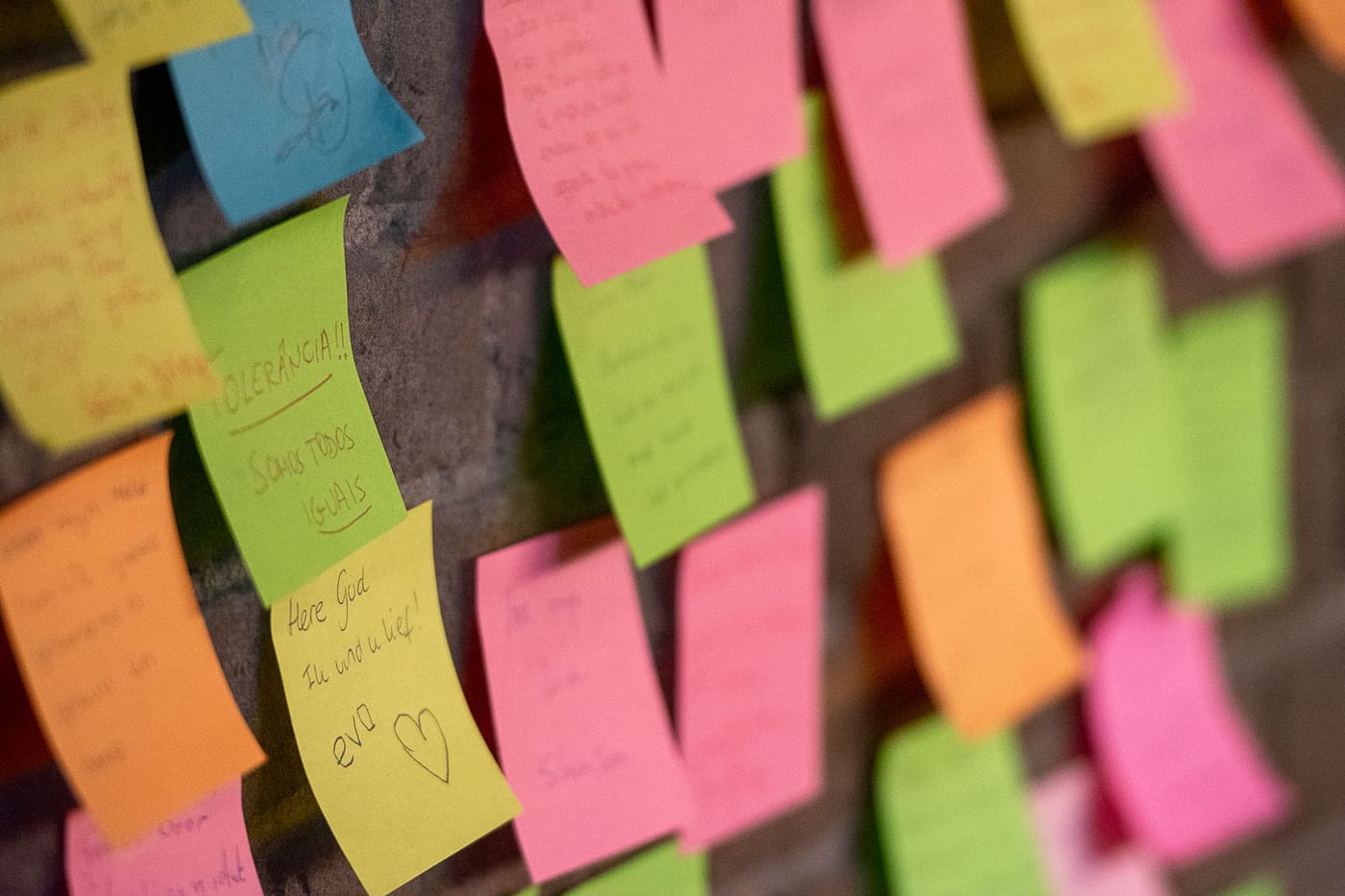 Close-up of many colored sticky notes covering a wall